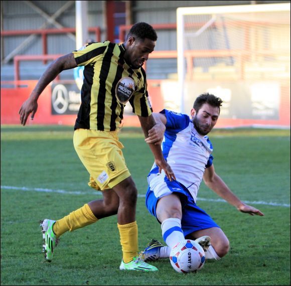 Nathan Modest is loses control to a sliding challenge from a Barrow defender