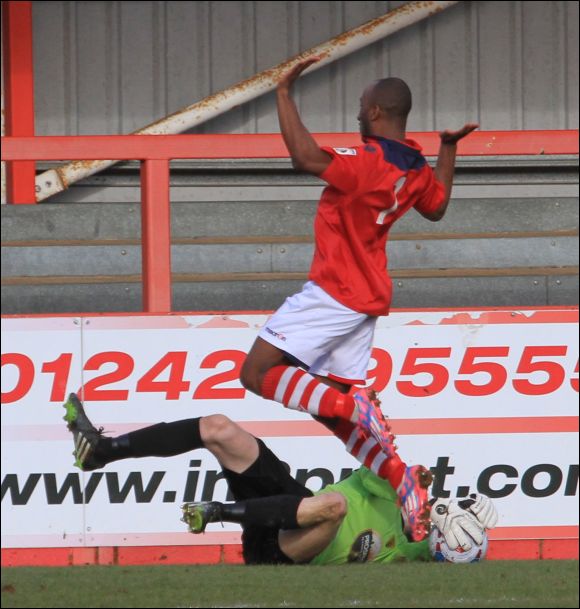 Colwyn Bay's Obi Anouro dances around as headless City keeper Paul White claims the ball