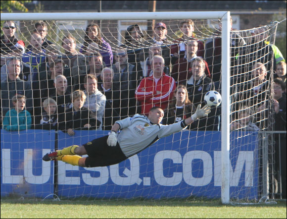 Lewis Carey dives full length to save Aiden Palmer's free kick