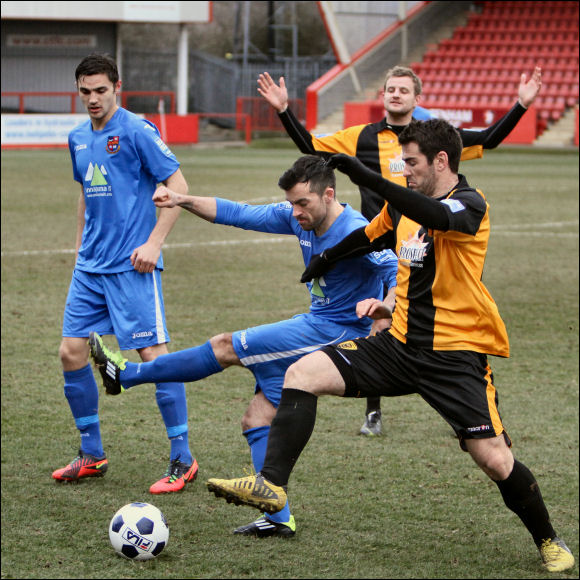 All arms and legs! City's Adam Mann nicks the ball off of a Harrogate player