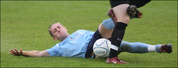 Lee Marshall slides in to tackle on the soaking wet East Thurrock pitch