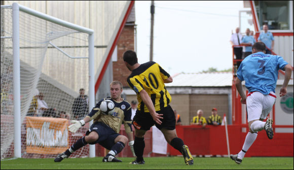 Hyde keeper Russell Saunders denies Mike Symons from a narrow angle