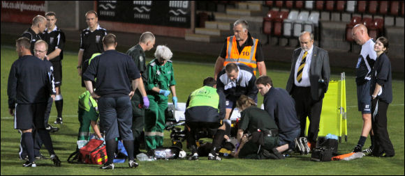 Jack Harris is treated on the pitch after breaking his leg against Corby