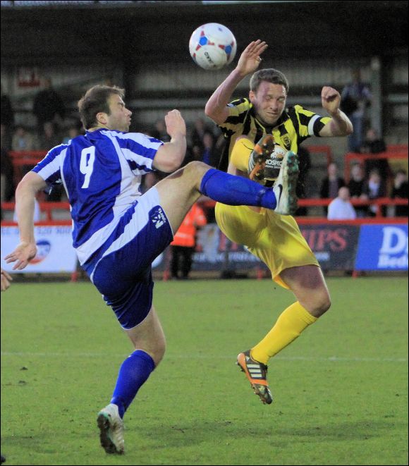 Tom Webb in some high kicking action with ex-City striker Mike Symons at Kidderminster tonight